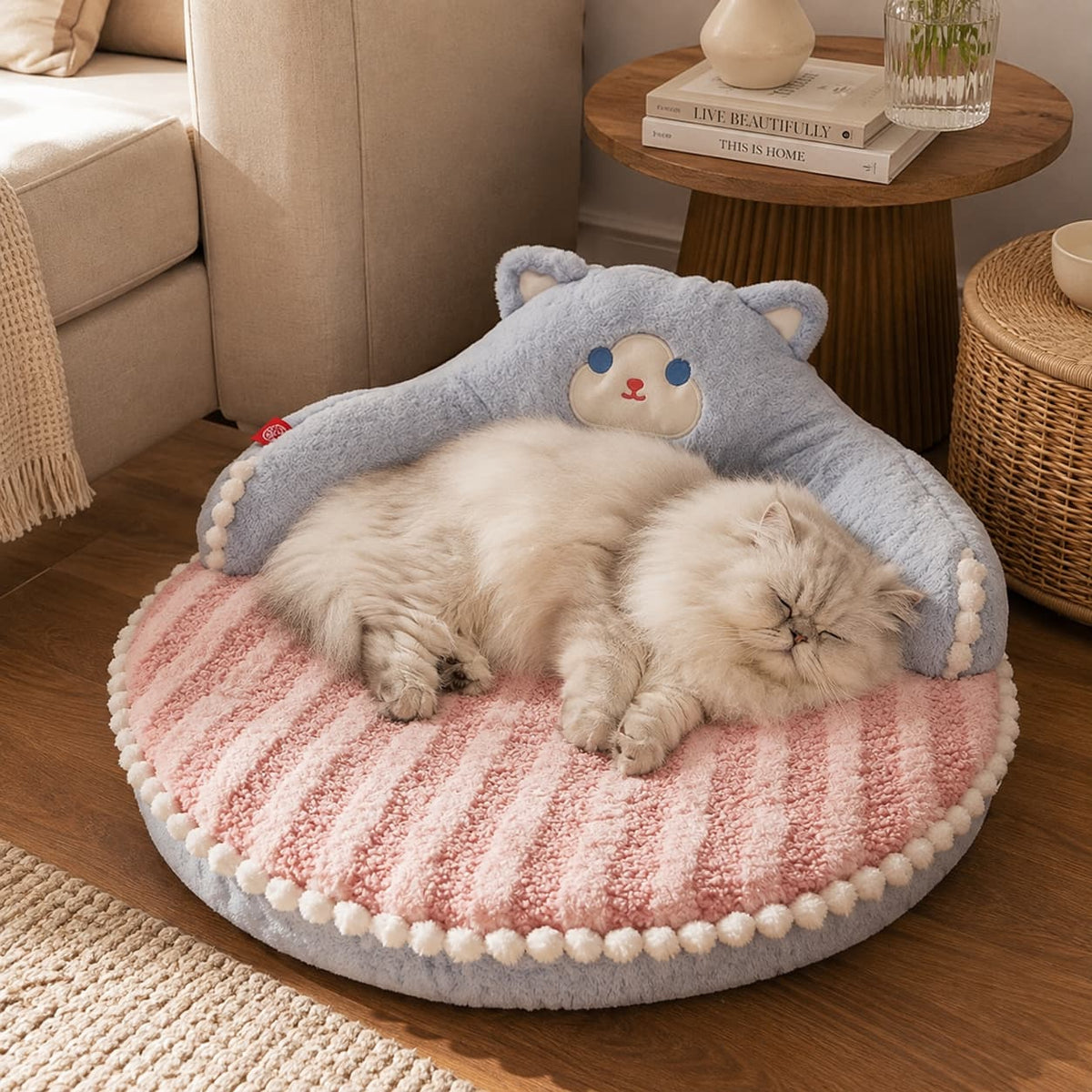 Fluffy cat resting on a soft blue and pink bear shaped pet bed in a cosy home