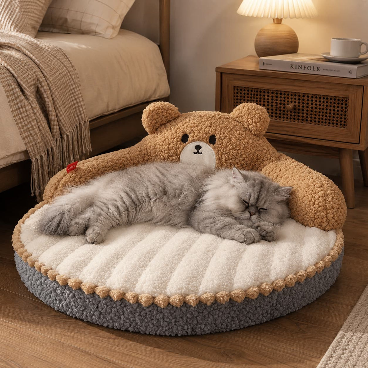 Grey cat sleeping peacefully on a soft brown bear pet bed beside a cosy bedroom