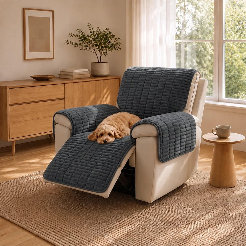 Cat sleeping on a dark grey quilted recliner cover protecting the chair, arms and footrest.