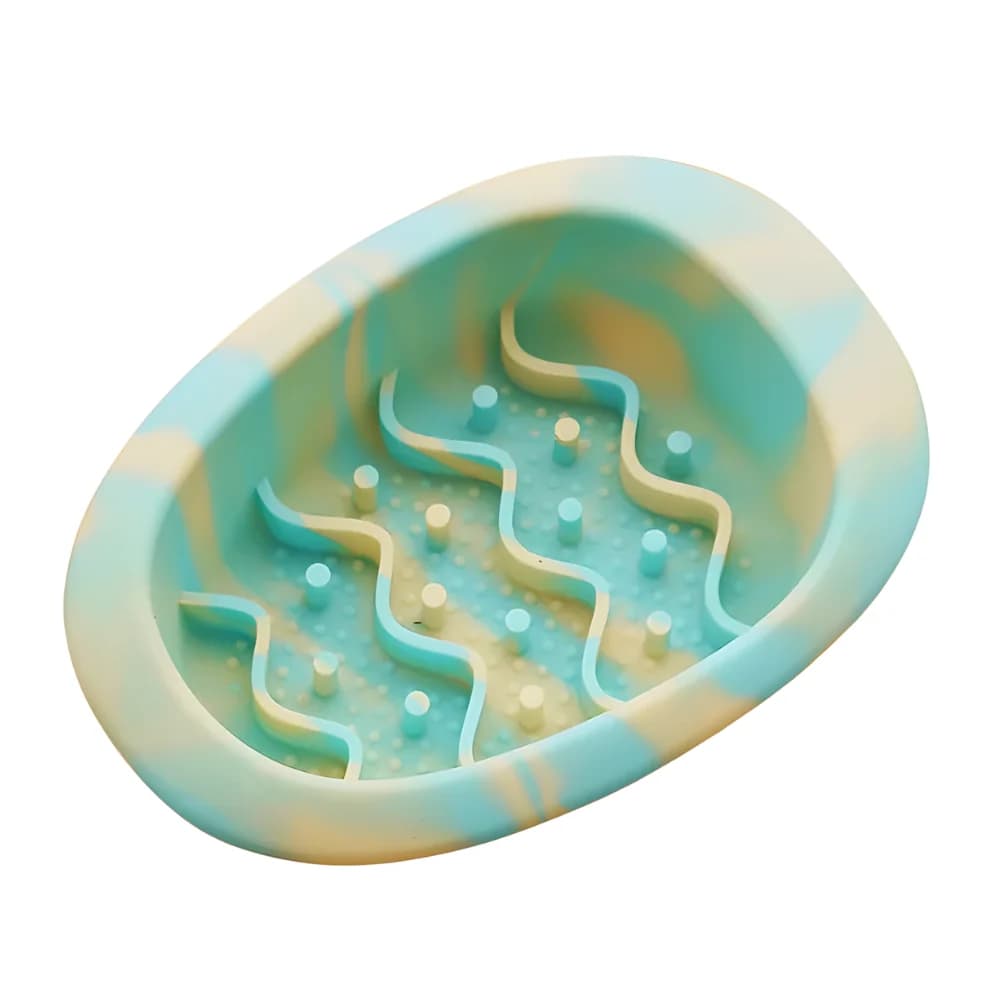Green and yellow pastel oval cat slow feeder bowl with raised maze pattern on a clean white background