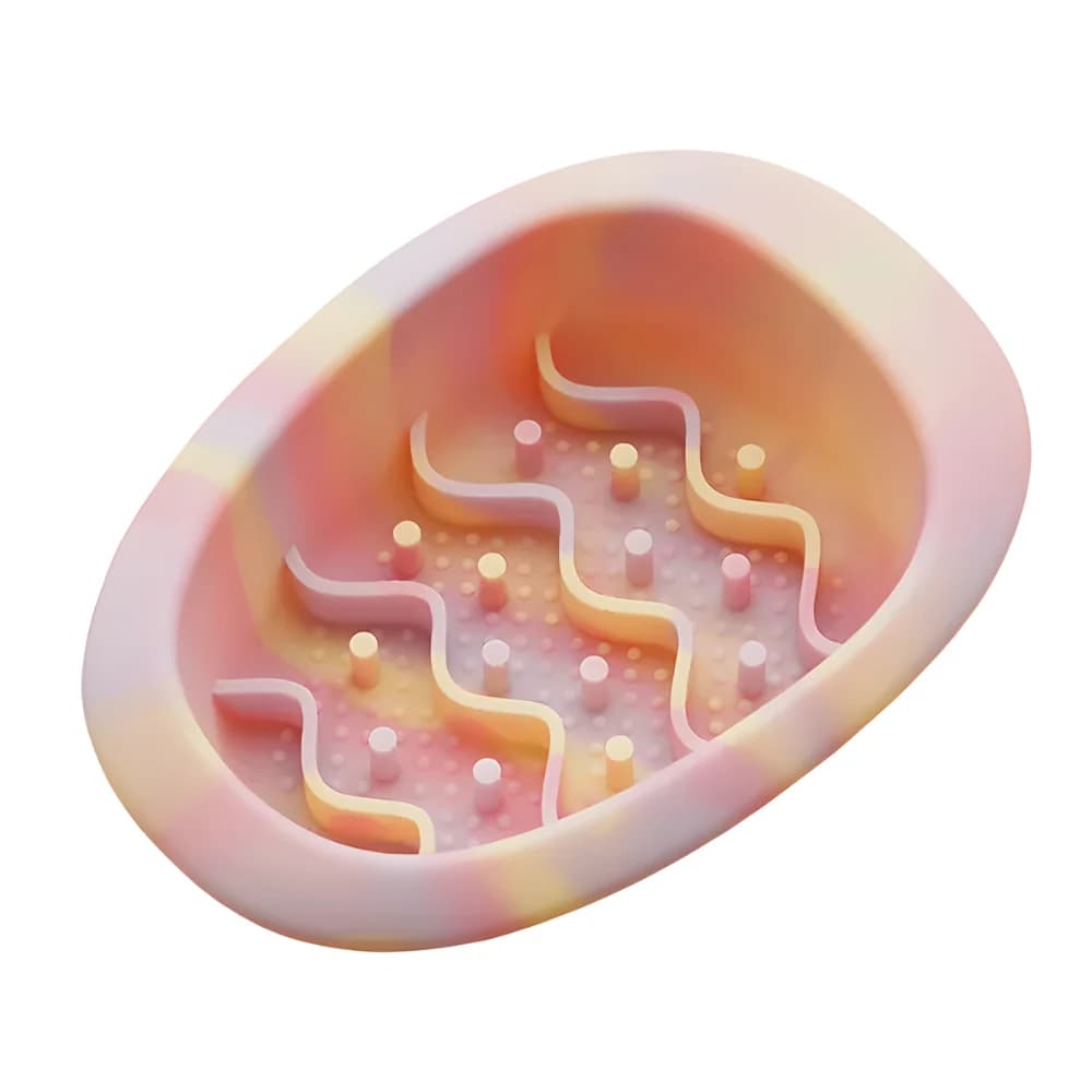 Pink and orange pastel oval cat slow feeder bowl with raised maze pattern on a clean white background