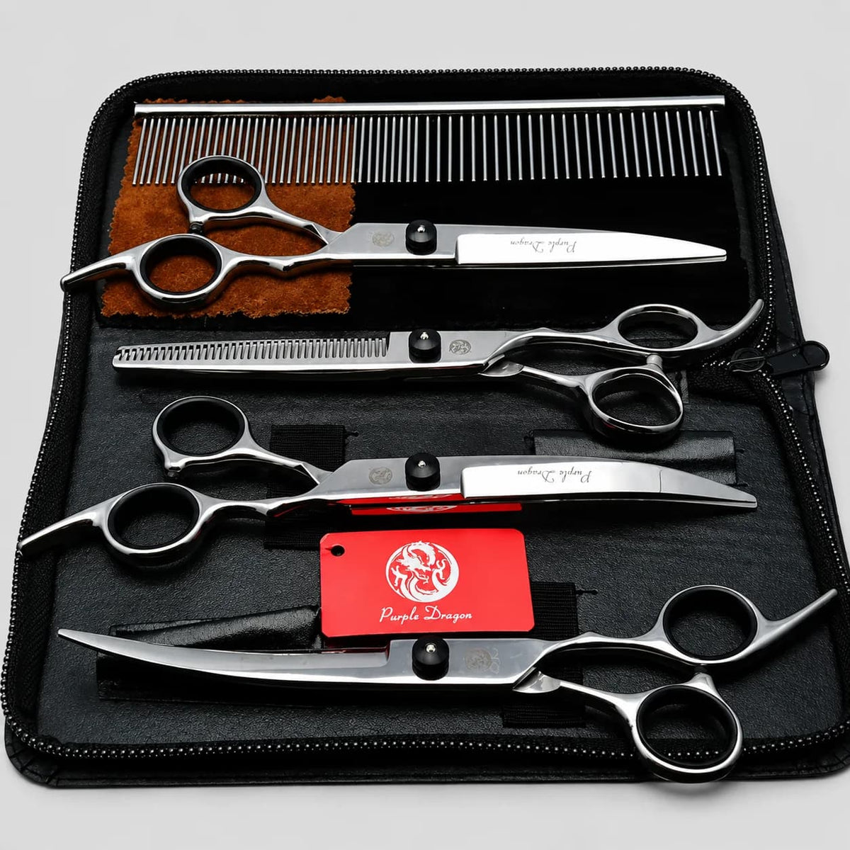 Complete black pet grooming scissors kit with multiple scissors, comb and accessories arranged inside a storage case.