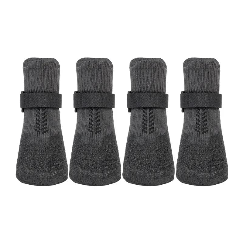 Four black protective dog boots displayed against a white background with adjustable fastening straps.